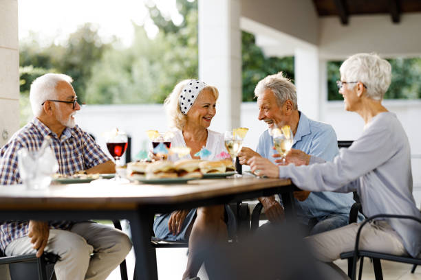 istock Happy senior friends talking while having a meal at patio. 1573344198
