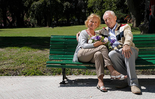 altes paar in einem park - senior adult women park bench 70s stock-fotos und bilder