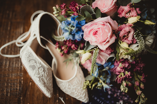 Wedding high heels made of lace and flower bouquet of the bride