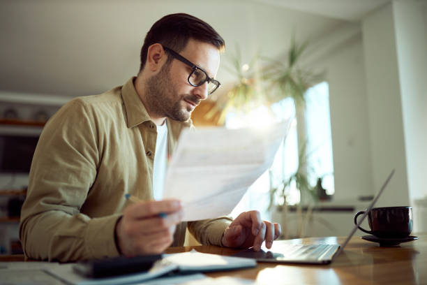 istock Young man working on his financial bills at home. 1573347855