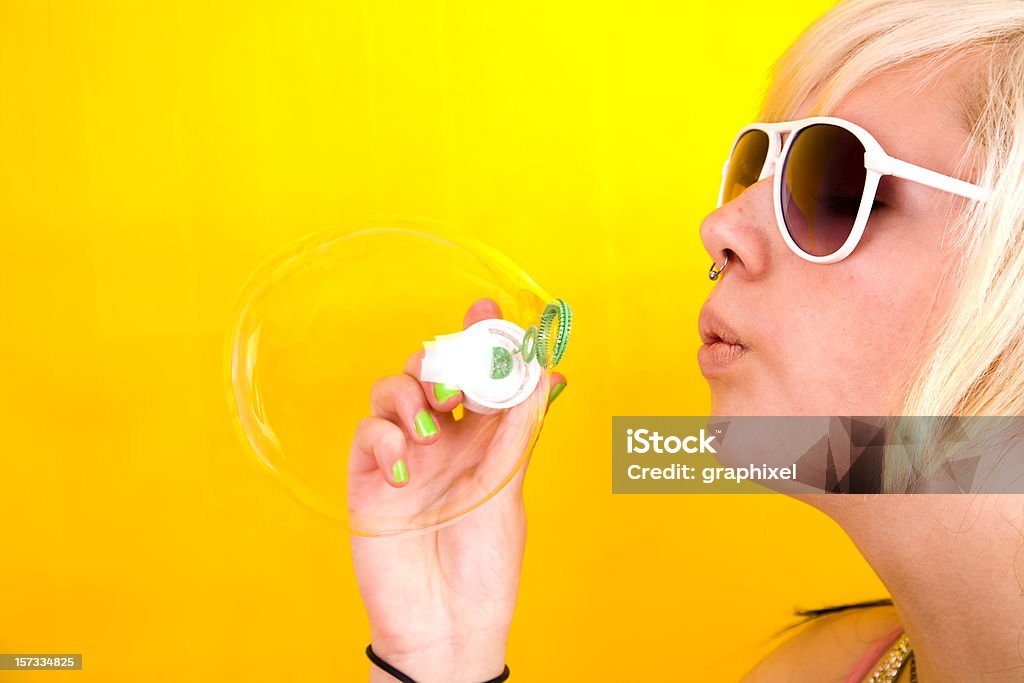 Teen Girl Teen girl on yellow background making bubble Adult Stock Photo