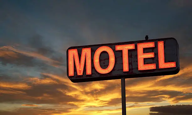 Motel sign with sunset