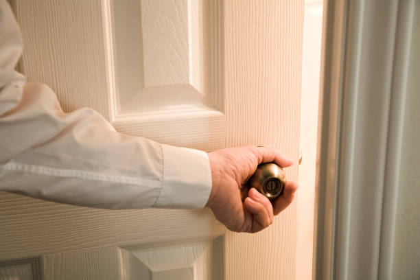 opening door into light unknown room Man's hand opening door into light unknown room of mystery and opportunity. Focus on doorknob and door. ajar stock pictures, royalty-free photos & images