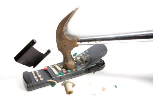 breaking the TV remote with a hammer