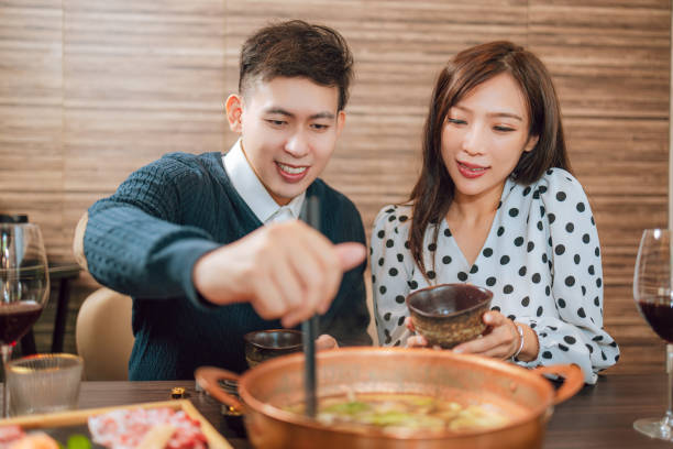 istock Happy couple dining in hotpots restaurant 1573352102