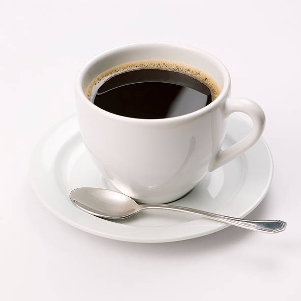 Espresso coffee cup with steel spoon on white