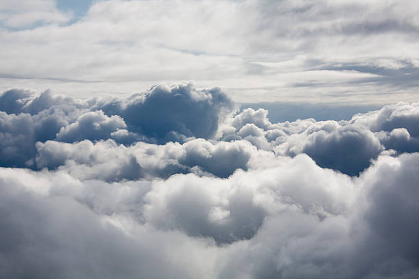 Fluffy white clouds from above stock photo