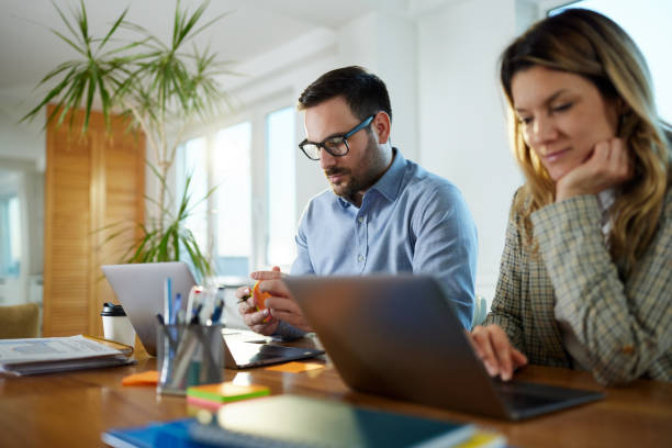istock Business couple working on computers at home office. 1573360361