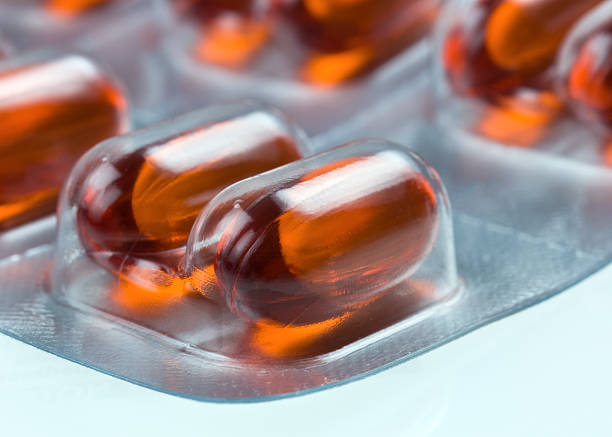 blíster de cápsulas de color rojo - capsule vitamin pill red lecithin fotografías e imágenes de stock
