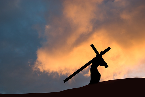 Christ carrying the Cross on Good Friday with a dramatic sky in the background.
