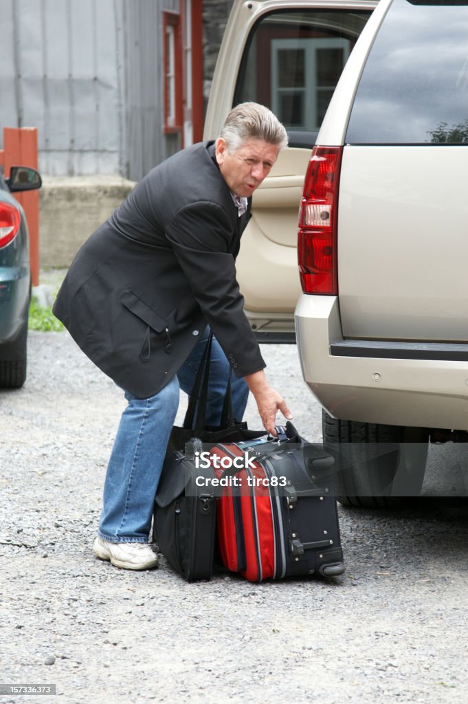 Uomo sollevando la valigia - Foto stock royalty-free di Uomini