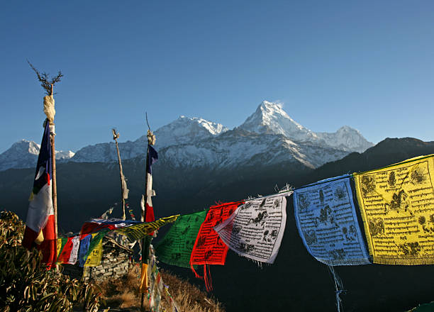 Colorful Tibetan prayer flags and the Annapurna mountains view of the Annapurna range with colourful tibetan prayer flags kathmandu stock pictures, royalty-free photos & images