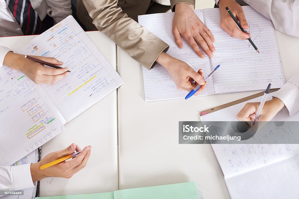 teacher tutoring students in classroom overhead view of teacher tutoring students in classroom Assistance Stock Photo