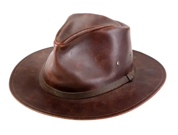 A well worn leather hat on a white background.