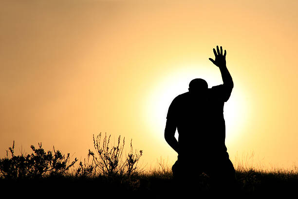 Silhouette of Man In Praise and Worship stock photo