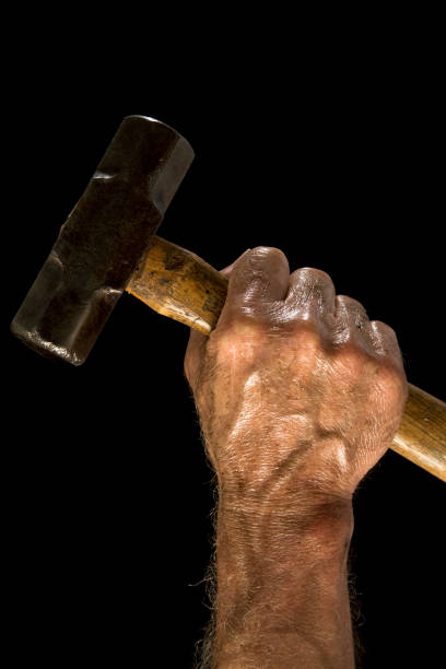 Man with sledgehammer. Dirty, greasy. Working class. Hand. Man holding sledgehammer against black background. metal stud stock pictures, royalty-free photos & images