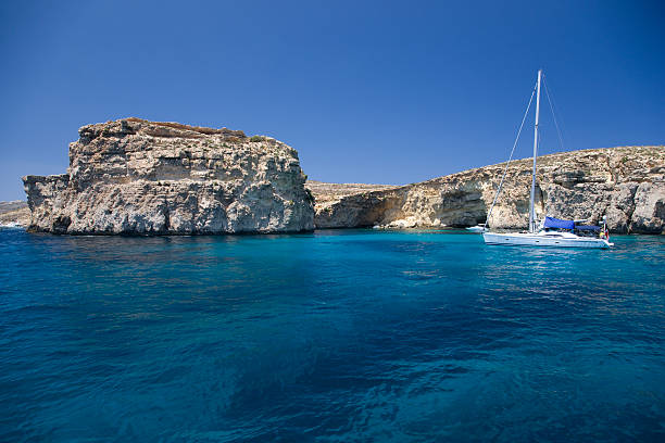 Sailboat anchored in beautiful blue lagoon in the Mediterranean Sea.