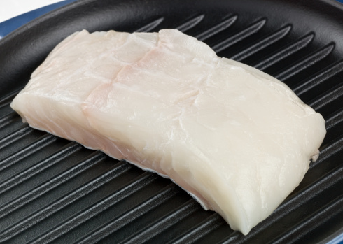 Fresh raw white fish fillet Pangasius with spices on a stone background with copy space for your text
