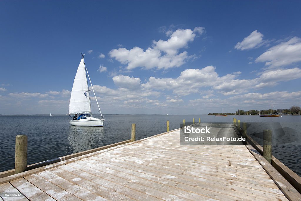 El embarcadero del lago con blanco yacht y magestic nubes (XL - Foto de stock de Actividad de fin de semana libre de derechos