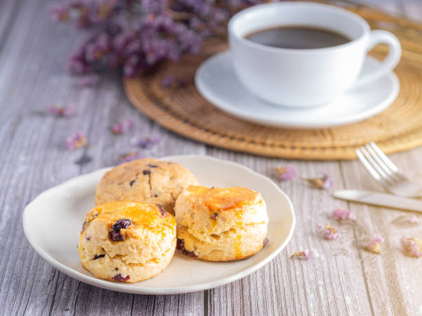 side view of traditional british scones and cookie with a white coffee cup - brownie tea afternoon tea scone imagens e fotografias de stock