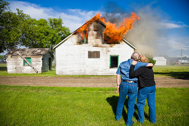 Couple's House on Fire Couple watch as their house is burning to the ground. burning house stock pictures, royalty-free photos & images