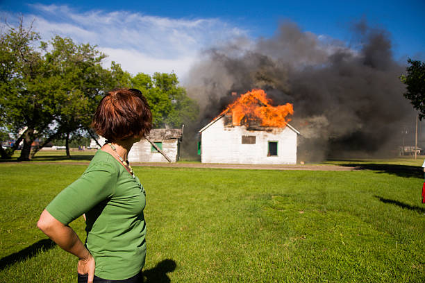 Woman observing house fire Woman observing house fire burning house stock pictures, royalty-free photos & images