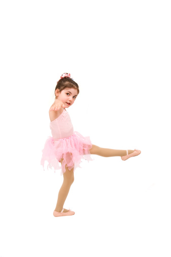 Full-length portrait of a little girls practicing her ballet kicks on a white background; copy space 