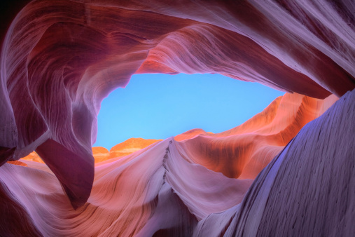 Colourful sandstone and light with a blue sky, in a slot canyon (the Lower Antelope Canyon) , Page, Arizona, USA