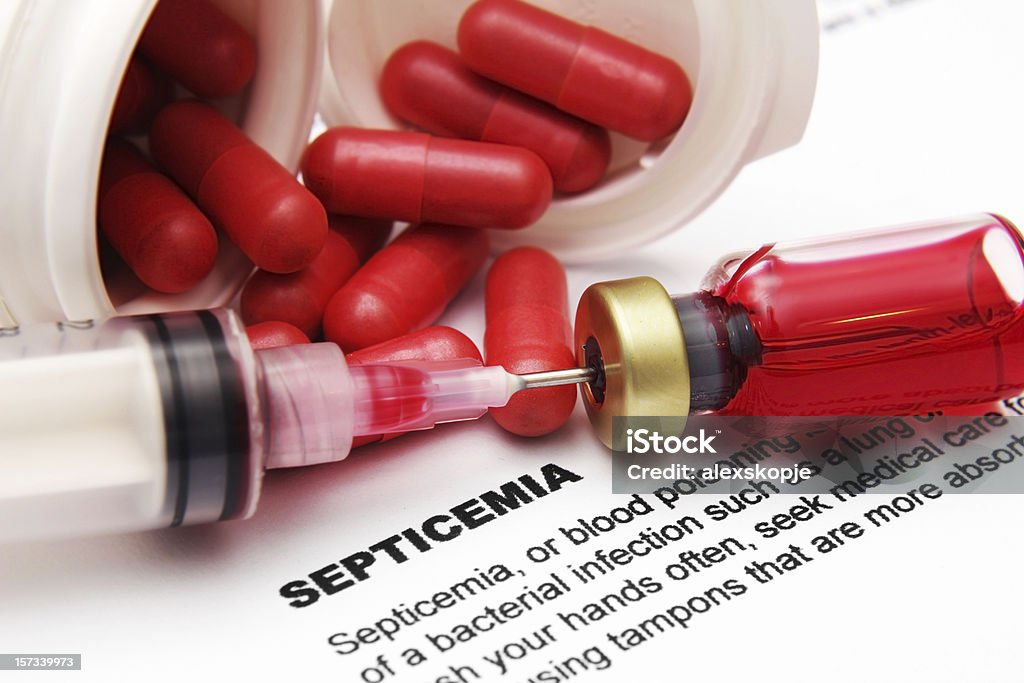 Pills and needle in vial on paper with info on septicemia Close up of syringe vial and pills on Septicemia text Sepsis Stock Photo
