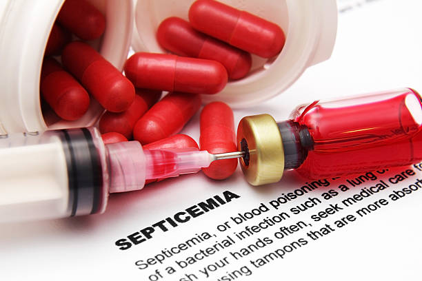 Pills and needle in vial on paper with info on septicemia stock photo