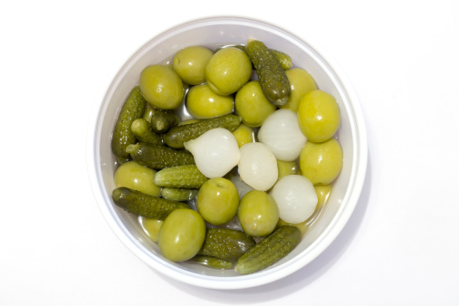 Olives, pickles and chives on white table