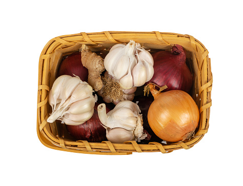 Vegetables in a Basket Isolated, Onions, Garlic Bulbs, Ginger in a Rustic Wicker Basket on White Background Top View, Clipping Path