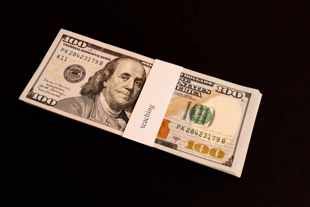 istock A stack of dollars with the inscription education on a dark background. 1573442100