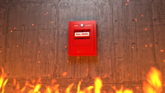 Fire alarm button on concrete wall with flames