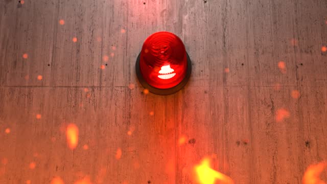 Red emergency siren light on concrete wall with flames