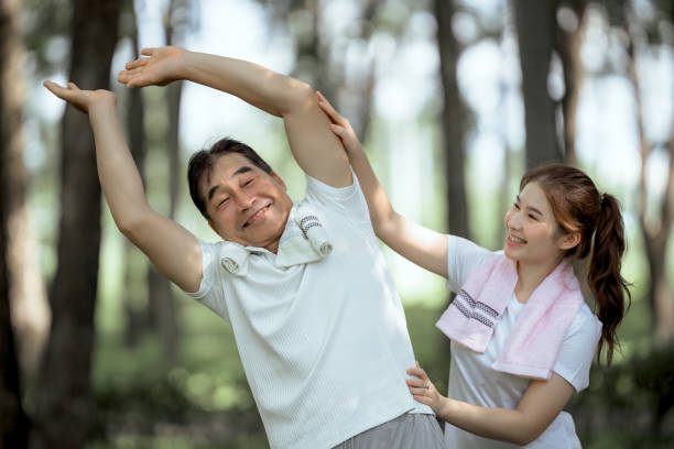 Beautiful Asian woman taking her father and mother to exercise in the park happily, with a smile. Young woman invites parents to exercise, warm family, good health. concept health care life insurance. hermosa mujer asiática que lleva a su padre y a su madre a hacer ejercicio en el parque felizmente, con una sonrisa. la joven invita a los padres a hacer ejercicio, a una familia cálida, a una buena salud. concepto de seguro de vida para el cuidado de la