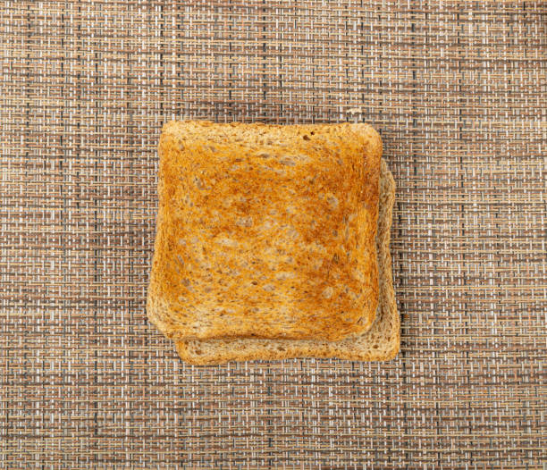 istock Bread Toasts on Rustic Background, Toasted Sandwich Square Slices, Loaf Pieces for Toast on Brown Tablecloth 1573473131