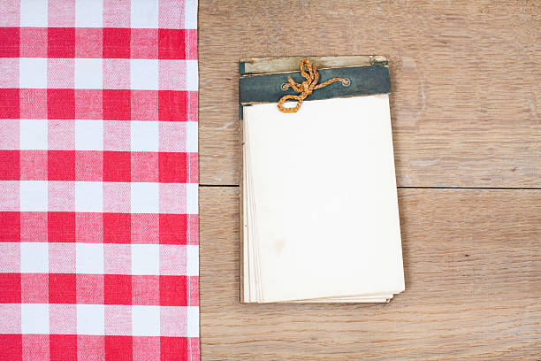 istock Tablecloth textile texture, old cookbook on wooden table background 157348535