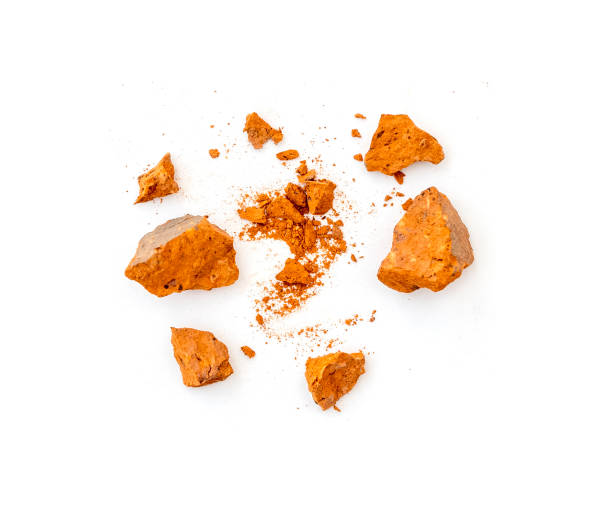 istock Flying pieces and powder of broken red brick isolated on white 1573485616