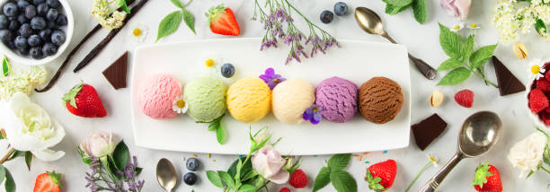 istock Set of various ice cream scoops and ingredients on white marble background, top view 1573500096