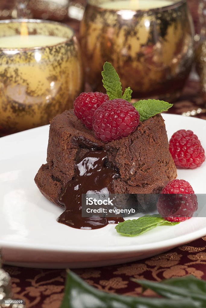 Raspberry Lava Cake Delicious dark chocolate lava cake dessert served with fresh raspberries and mint. Surrounded by Christmas ornaments. Molten Chocolate Cake Stock Photo