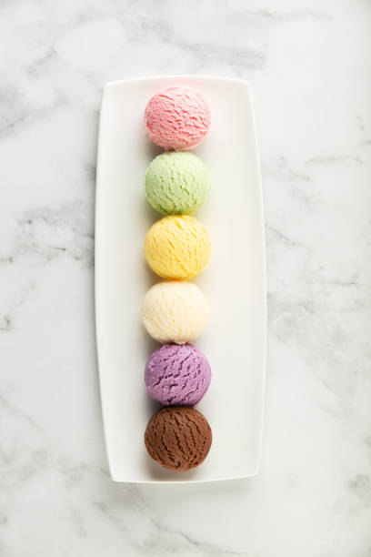 istock Set of various ice cream scoops on white marble background, top view 1573500616