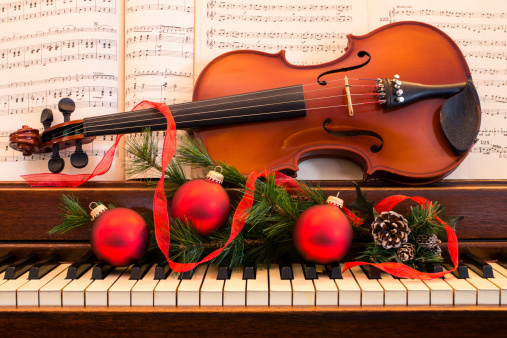 A piano and violin are decorated for the Christmas Holiday. 