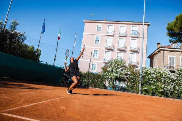 tennis racket with two balls on clay court