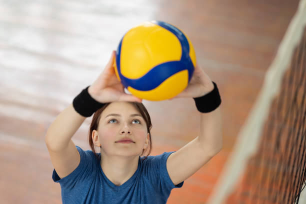 istock Young girl setting the ball over the net before hitting it 1573523637