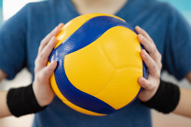 Close up of volleyball ball in hands of female player stock photo