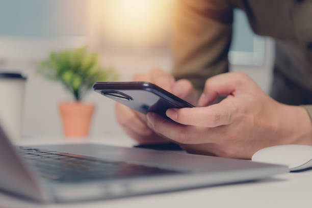 istock Man or Creative Freelancer working on Laptop and Phone at Office Desk. Business Technology, communication, and global networking Innovation, collaboration, and success in the digital world 1573525783