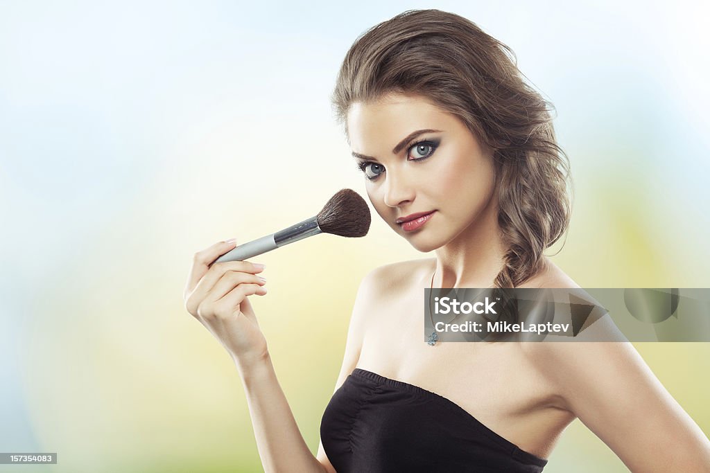 Donna con un Pennello da trucco - Foto stock royalty-free di Adulto