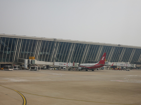 Shanghai, China - 12 4 2017: Shanghai airlines airplane is loading at International airport Pudong, China. Pudong international airport is a major aviation hub of China.