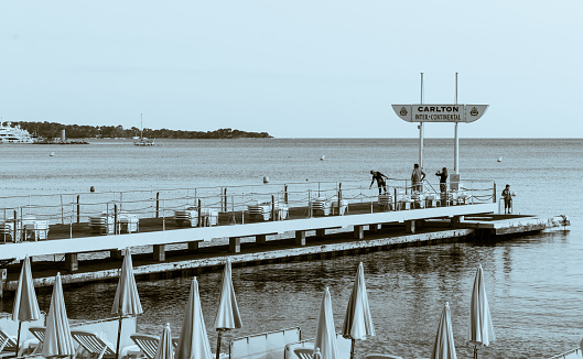 Cannes France - April 30 2011; Rows of hotel sunloungers with umbrellas down in late afternoon on French Riveria.